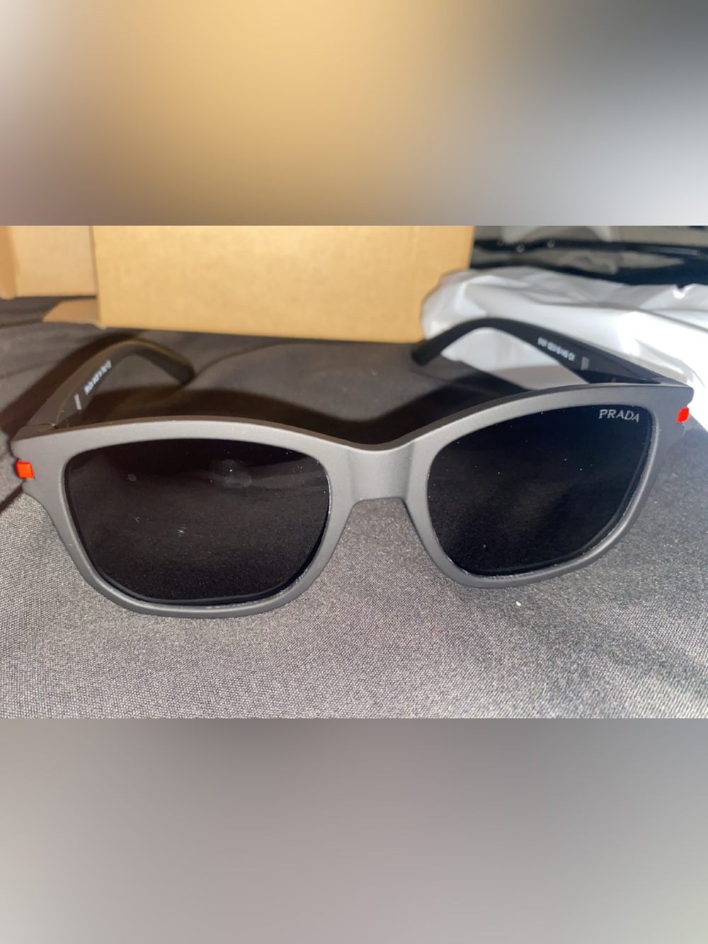 Prada Men’s Matte Gray Frame Sunglasses with Black Lenses and Red Temple Accent